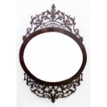 Mahogany pierced wall mirror, the oval portrait oriented glass surrounded by a band of purfling