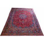 Mashad carpet, with central medallion flanked by red and blue floral fields and borders, 384cm x