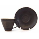 Lucie Rie cup and saucer, the brown glazed body has scratched liner decoration, impressed monograms,