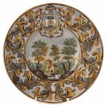 Maiolica bowl possibly Castelli, with armorial crest painted with a landscape within leaf scroll