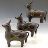 Three Chinese patinated bronze and champlevé enamel censers modelled as deer in harness, their backs