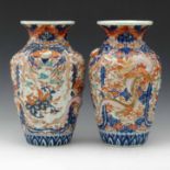 Pair of Japanese Imari vases moulded with dragons pursuing the flaming pearl and painted with