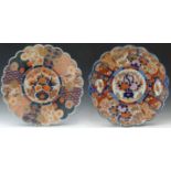 Two Japanese Imari foliated chargers painted in iron-red, blue and gilt with a central vase of