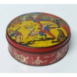 A vintage biscuit tin, circular, decorated to the cover with three clowns performing in a circus