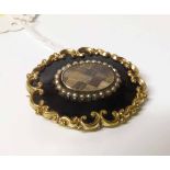 A 19th century yellow metal mourning brooch, oval, with a central chequered hairwork panel with a