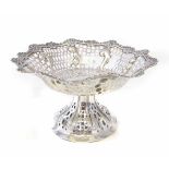 A silver comport, the pedestal form with pierced triangle oval and quarter floral patterning, flower