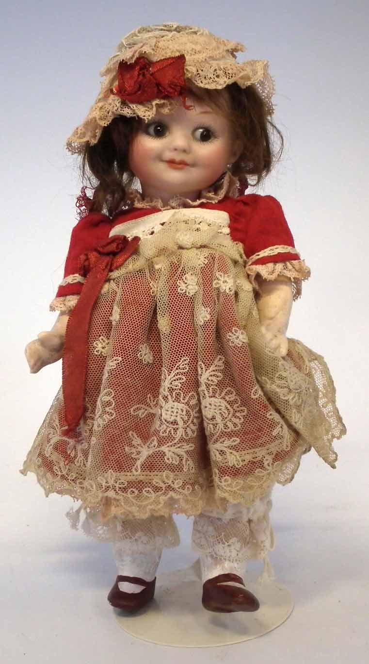 Armand Marseille 'googly eye' doll, mould number 323 4/0, dressed in red costume, with stand, 22cm