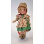 Demalcol 'googly eye' doll, mould number 5/0, dressed in green tunic, with stand, 23cm high