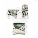 Silver Art & Crafts design three piece cruet set with green glass, by Levi & Salaman, scroll work at