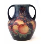 Moorcroft twin handled vase, decorated with Birds Pecking Fruit pattern on blue ground, impressed