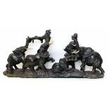 Carved granite group of a family of seven elephants at leisure, mostly with ivory tusks, length 93cm