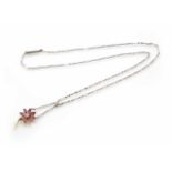 An Edwardian diamond and ruby flower head pendant with small pearl dropper. Small round old cut