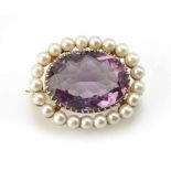 Amethyst and cultured pearl oval cluster brooch. The central oval amethyst approx. 20mm x 15mm. 21