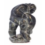 Carved soapstone figure probably Isah Sheeq, depicting an Inuit holding a seal, 17cm high