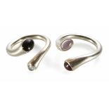 A pair of Georg Jensen silver stone set rings. The crossover ring tubular design with oval