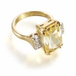 A yellow sapphire single stone 18ct yellow gold ring with diamond set shoulders, the rectangular