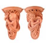Pair of Watcombe Pottery terracotta wall shelves by Joseph Ellis, sculpted with two cherub