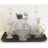 Three cut glass decanters, a Claret Jug with plated mounts, another Claret Jug with enamelled