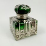 A French Art Deco square glass inkwell, with inlaid silver decoration and hinged green glass cover,