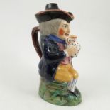 A late 19th century covered toby jug, modelled as a seated man holding a bear jug in both hands,