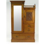 An Edwardian satin walnut wardrobe, with mirror door flanked by a carved door,