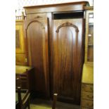 A mahogany wardrobe, having panelled doors opening to reveal shelves, drawers and a hanging space,