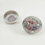 Two 19th century millefiori glass paperweights, one decorated with rings of flower heads,