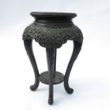 An oriental jardinere stand, of circular form with carved frieze,