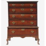 An 18th century walnut chest on a stand, fitted with four cross banded graduated long drawers,