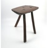 An Antique primitive stool, the rectangular top raised on three legs, 14ins x 9ins x 16.