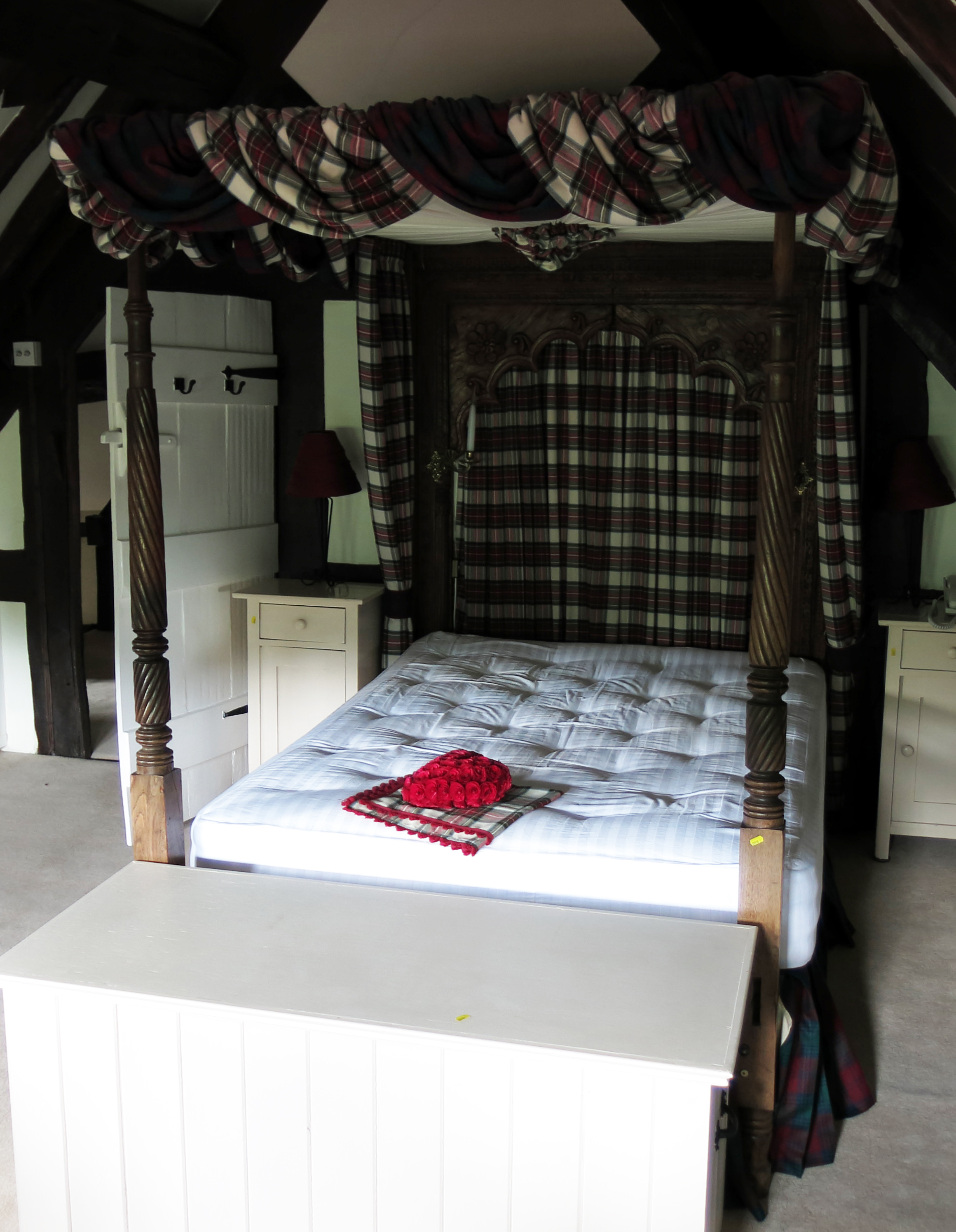 An antique oak tester bed, the rectangular headboard with arched panel,