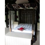 An antique oak tester bed, the rectangular headboard with arched panel,