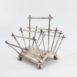 After a Christopher Dresser design, a Mappin and Webb silver plated toast rack of curved form,