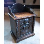 A 19th century carved oak purdonium, with lion mask handles and ornate carving,