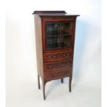 An Edwardian mahogany bow front cabinet, with glazed door revealing a shelf over three drawers,