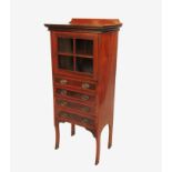 An Edwardian mahogany music cabinet, having a glazed cupboard over four cross banded drawers,