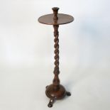 A 19th century mahogany candle stand, the sconce with tray below, raised on a barley twist column,
