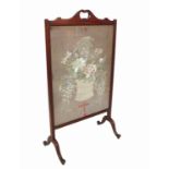 A fire screen, with an embroidered panel of a basket of flowers,