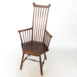 A Windsor armchair, with hexagonal shaped dished seat raised on turned legs united by a stretcher,