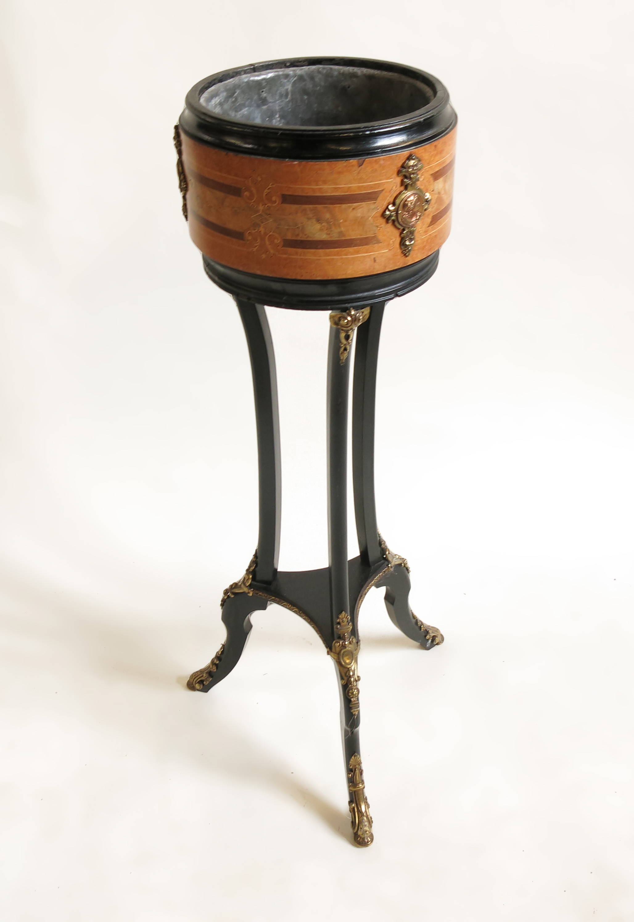 A 19th century circular ebonised jardinere stand, with a band of pollard oak,