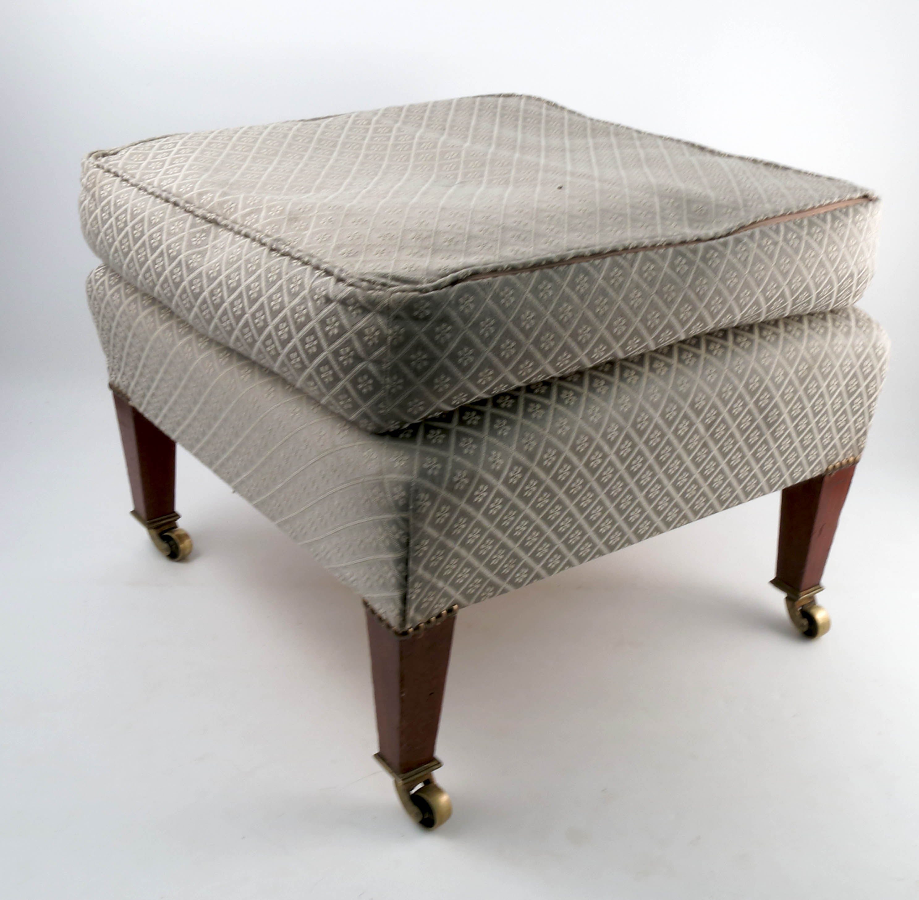 A late 19th century Howard and Sons square ottoman footstool, on square tapering mahogany legs,