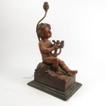 A carved wooden lamp base, modelled as seated putti playing a harp, on a rectangular base,