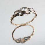 A late 18th century three stone diamond ring, the central silver collet set rose cut of oval shape,