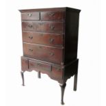 An Antique oak chest on stand, the upper section fitted two short over three long graduated drawers,