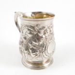 A Georgian silver mug, the baluster shaped body embossed with fruits, flowers and scrolling leaves,