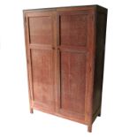 A 20th century limed oak wardrobe, in the Heals style, having two panelled doors,