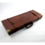 A leather covered motor gun case, of rectangular form, with brass corners and straps,