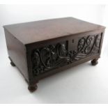 An Antique oak bible box, with plain rising lid, carved front panel and raised on turned feet,