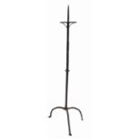 A similar antique iron pricket candle stand, the octagonal column raised on a tripod base,