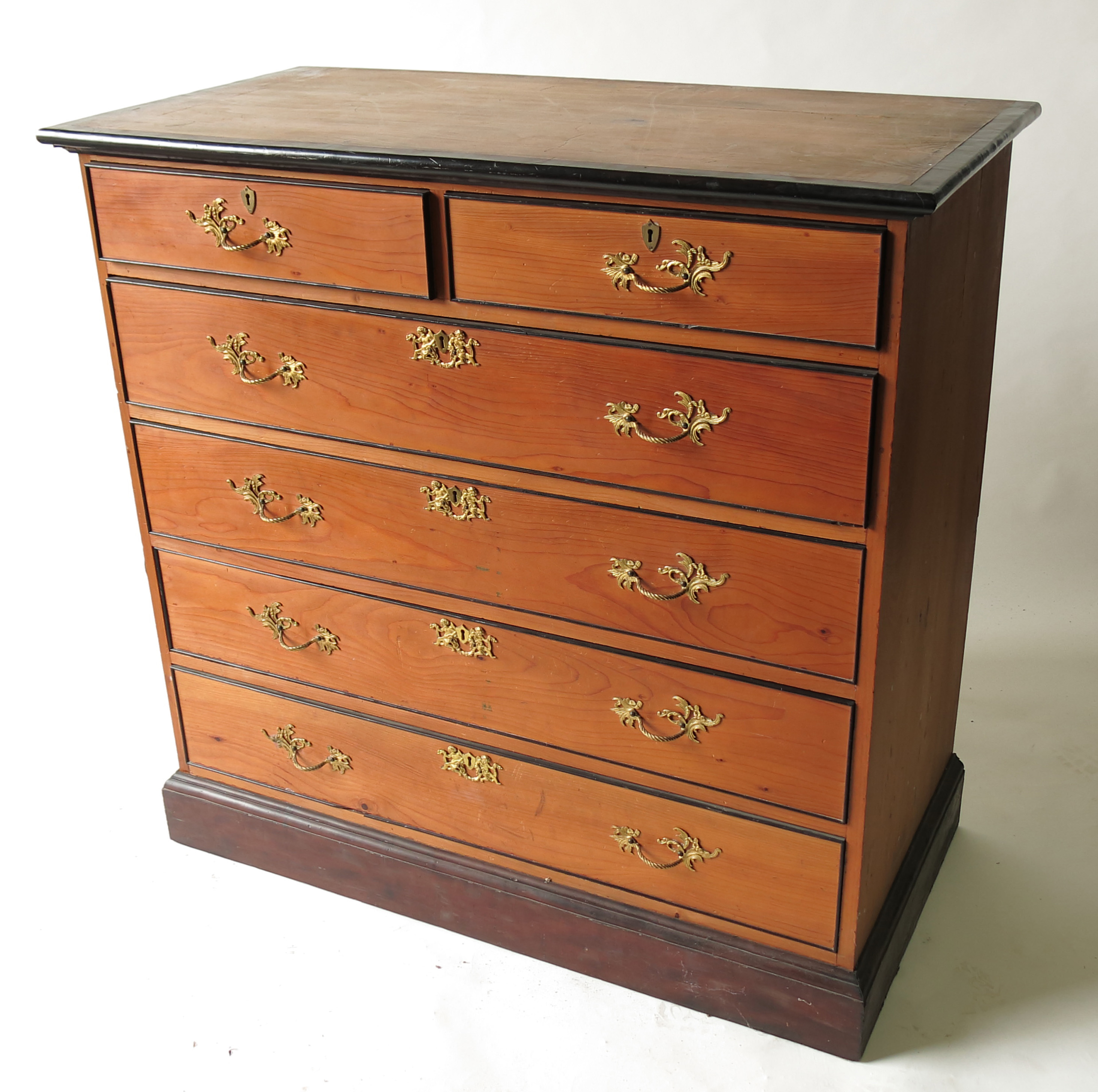 An Edwardian ebonised and pine chest, of two short over four long graduated drawers,